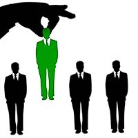 Three Black Figures In Business Suits, One Green Figure In A Business Suit. A Large Hand Has Picked The Green Figure Up